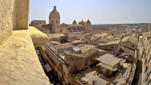 Buildings in city against clear sky