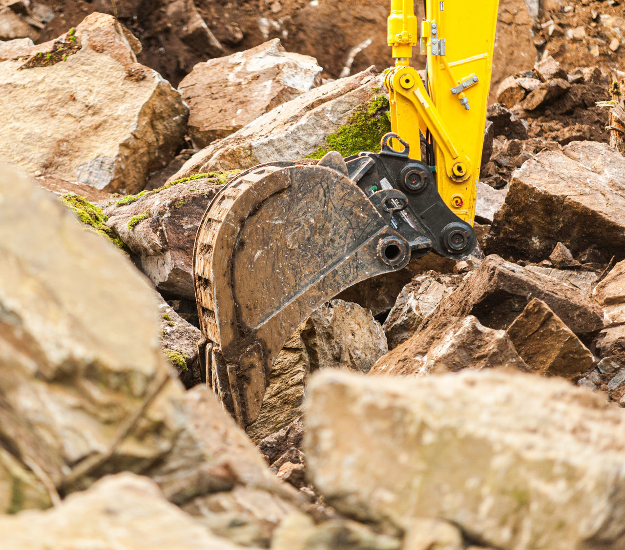 CLOSE-UP OF YELLOW MACHINERY ON ROCK