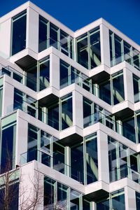 Low angle view of modern building against blue sky