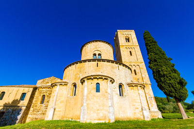 Low angle view of old building against clear blue sky during sunny day