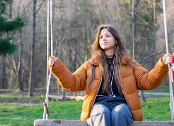 Portrait of a girl on a swing in the park.
