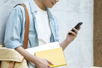 Midsection of man using mobile phone