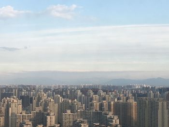 High angle view of cityscape against cloudy sky