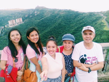 Portrait of happy family standing against mountain