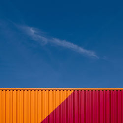 Low angle view of cargo container against blue sky