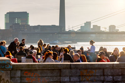 Group of people on bridge over river in city