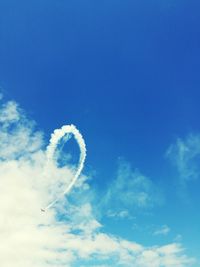 Low angle view of vapor trail against blue sky