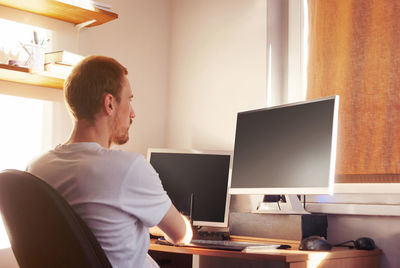 Man using mobile phone while sitting on table