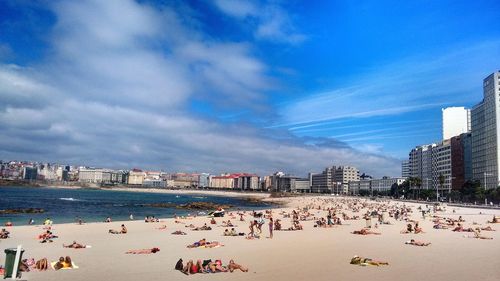 People in city against cloudy sky