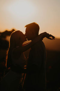 Rear view of man standing against sky during sunset