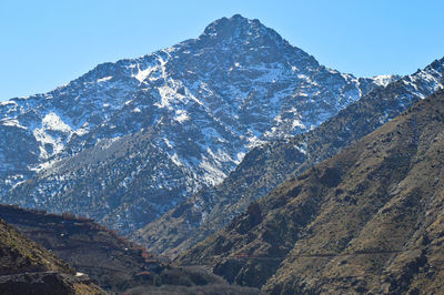 Aerial view of snowcapped mountains against clear sky