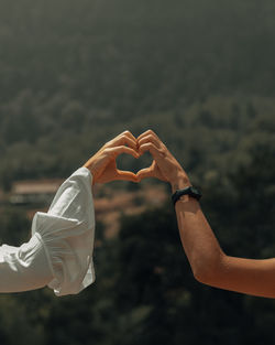 Midsection of couple holding heart shape