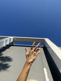 Low angle view of person against blue background