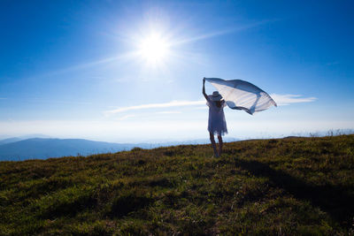 Man standing on field against bright sun