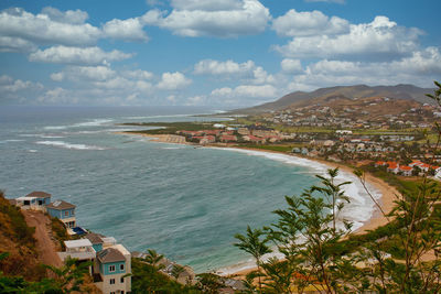 High angle view of townscape by sea against sky