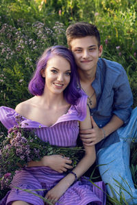 Lovers are a beautiful guy with a girl with purple hair and a bouquet of flowers sitting