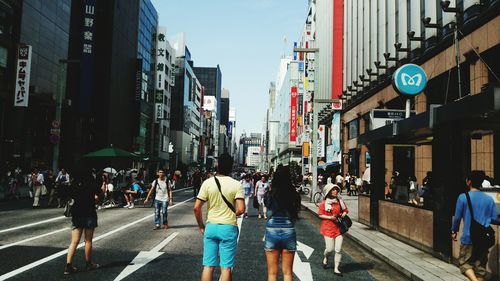 People walking on road along buildings