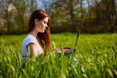 Young woman standing amidst plants