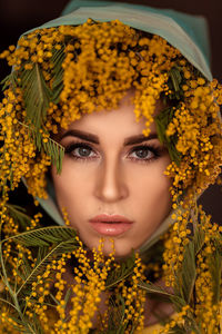 Portrait of a young woman in yellow mimosa flowers