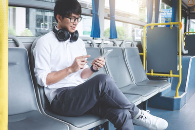 Young man using mobile phone while traveling in train