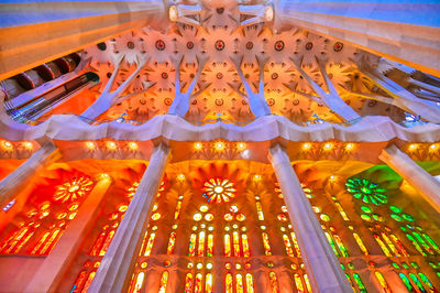 Low angle view of illuminated lighting equipment in building