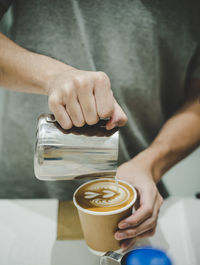 Midsection of man holding coffee cup