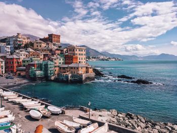 Scenic view of sea by buildings against sky