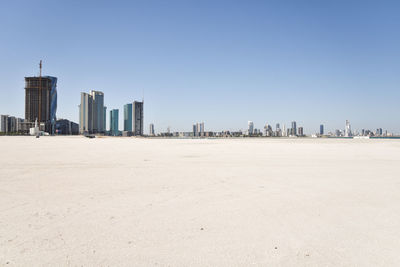 Manama skyline with skyscrapers and desert sand beach in kingdom of bahrain 