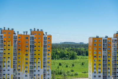 Buildings in city against clear blue sky