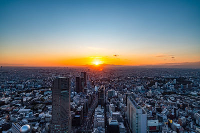 High angle view of modern buildings against sky during sunset