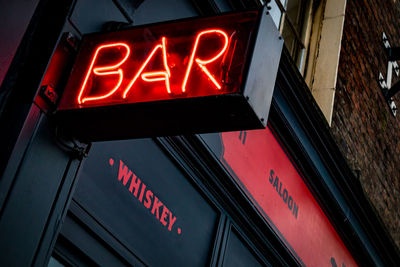 Low angle view of illuminated sign on building at night