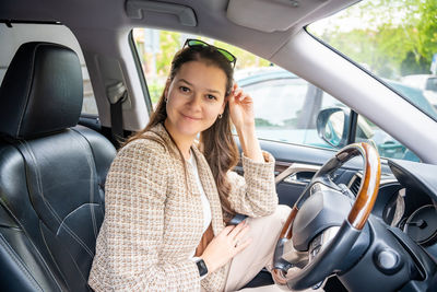 Portrait of young woman sitting in car