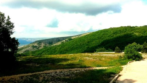 Scenic view of green landscape against sky