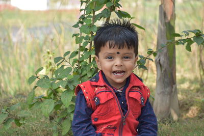 Portrait of boy standing against plants