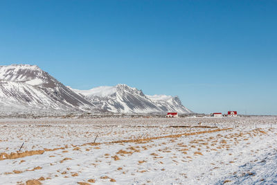 Scenic view of snowcapped mountains against clear blue sky