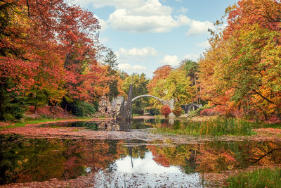 Stone arch bridge kromlau in brightly colored autumn, called rakotz bridge or devils bridge, saxony,