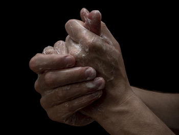 Close-up of human hand against black background