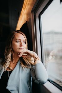 Thoughtful woman looking through train window