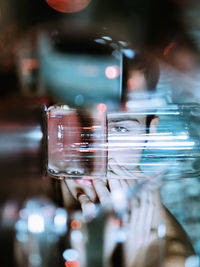 Portrait of young man lying on table seen through drinking glass at home