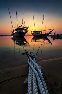 Fishing boat in sea against sky during sunset