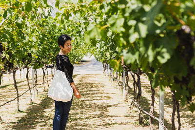 Rear view of young man standing against plants