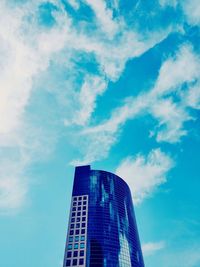 Low angle view of modern building against cloudy sky