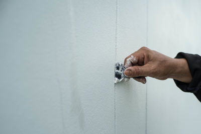 Close-up of hand holding wall