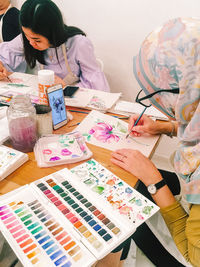 High angle view of woman holding multi colored umbrellas on table