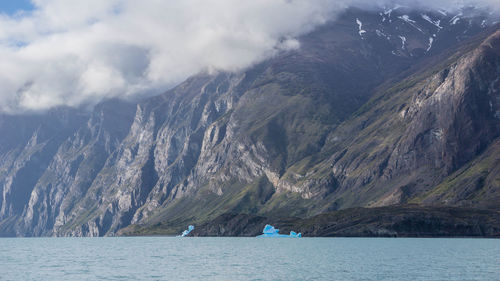 Scenic view of sea and mountains against sky