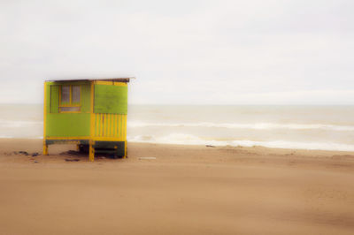 Lifeguard hut on beach against sky