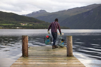 A fisherman about to drop some crab pots off a dock in norway