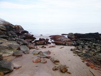 Rocks on beach against sky