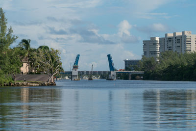 Buildings by sea against sky