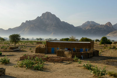 Scenic view of house and mountains against sky